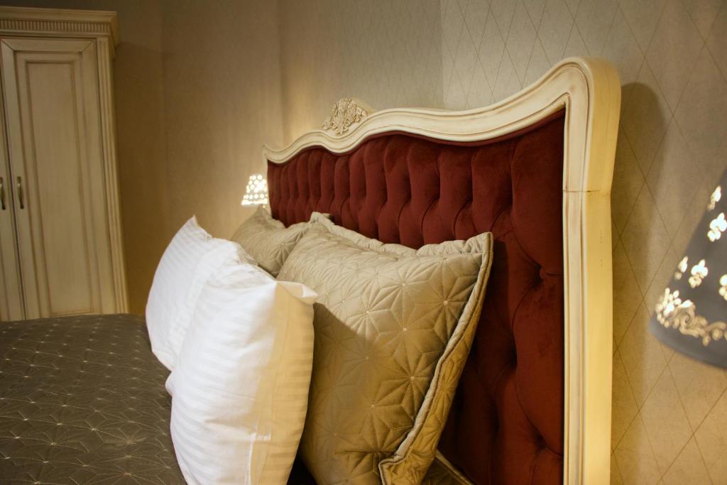 a bed with a wooden headboard with pillows at Hotel Schlossberg in Meißen