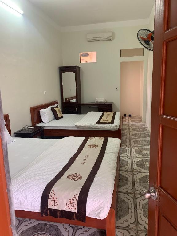 a room with two beds and a mirror at Khách sạn Thuỷ Chi in Bắc Quang