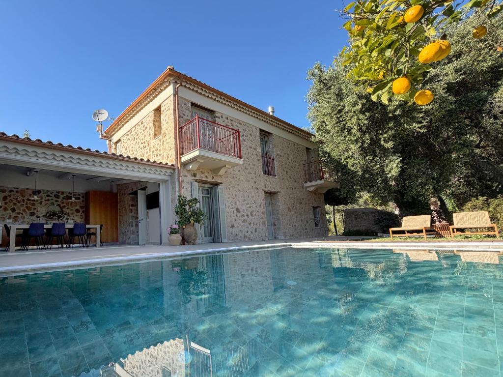 eine Villa mit Swimmingpool vor einem Haus in der Unterkunft Villa Anthousa luxury villas and suites in Anthoúsa