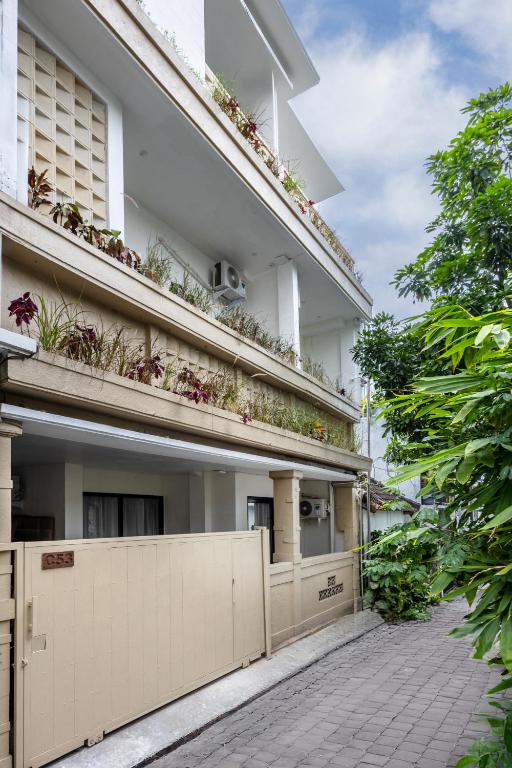an apartment building with plants on the balconies at Pyramid Ateliero Hotel Canggu in Canggu