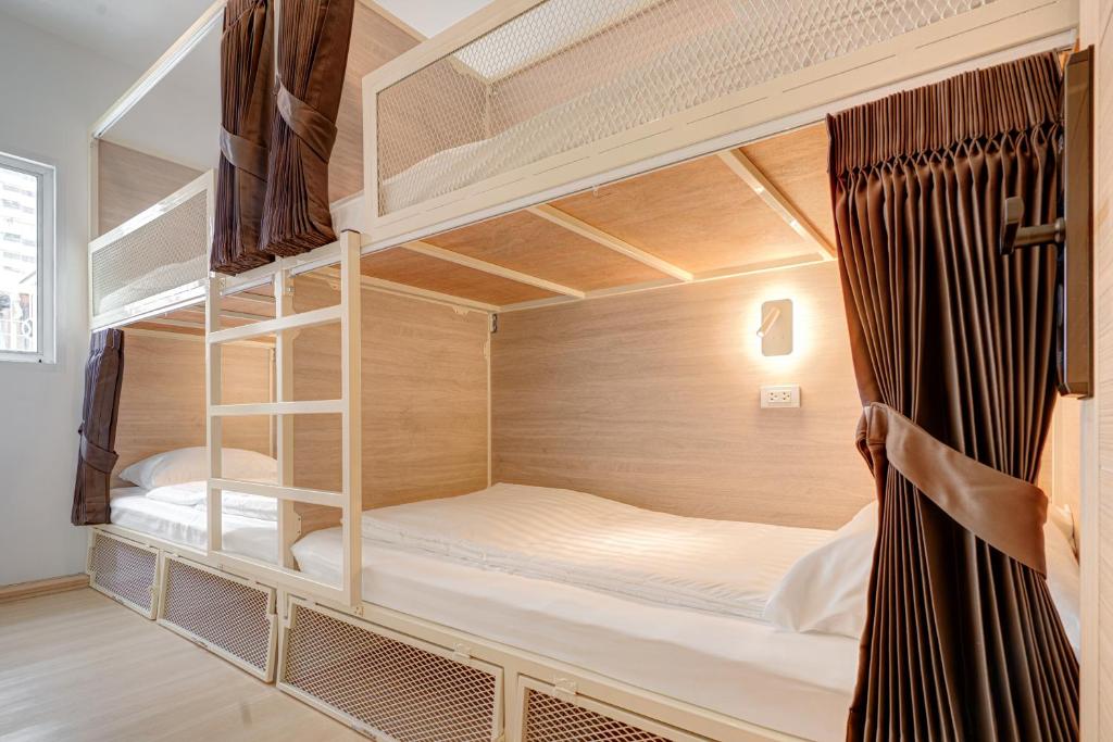 a bedroom with bunk beds in a hostel at The Ostel Hostel Bangkok in Bangkok