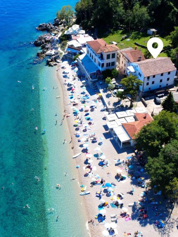 an aerial view of a beach with people in the water at Apartments Sveti Ivan in Mošćenička Draga