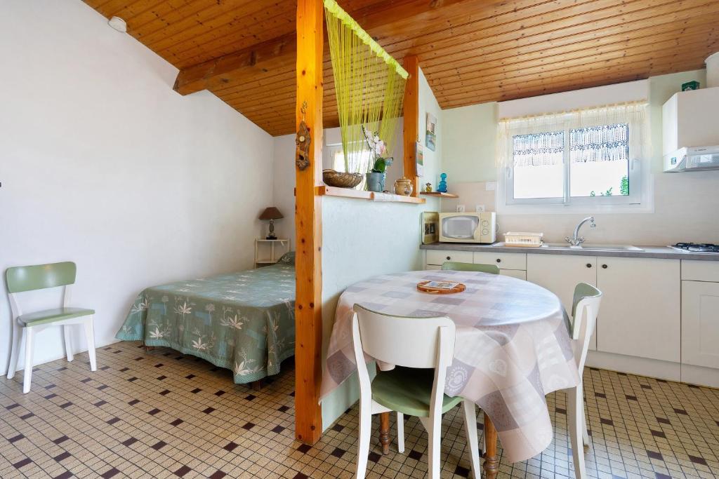 a kitchen with a table and a small table and chairs at Studio à La Ferme in Sémussac