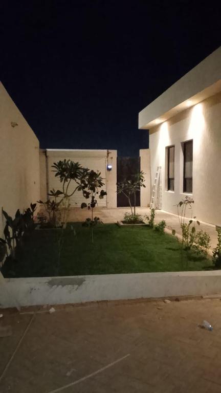 a house at night with a grass yard in front at جناح ريفي in Al Yamāmah