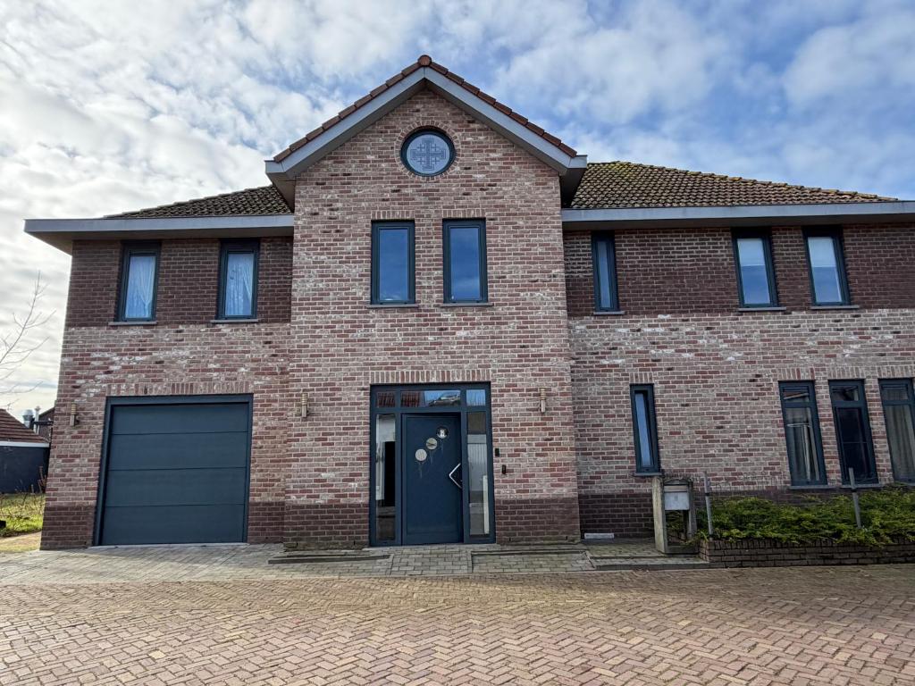 a brick house with a clock on top of it at Bed & Bresjes in Breskens