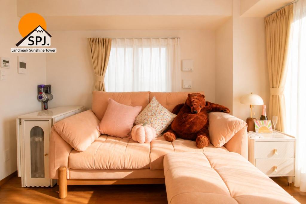 a teddy bear sitting on a couch in a living room at Landmark Sunshine Hotel in Osaka
