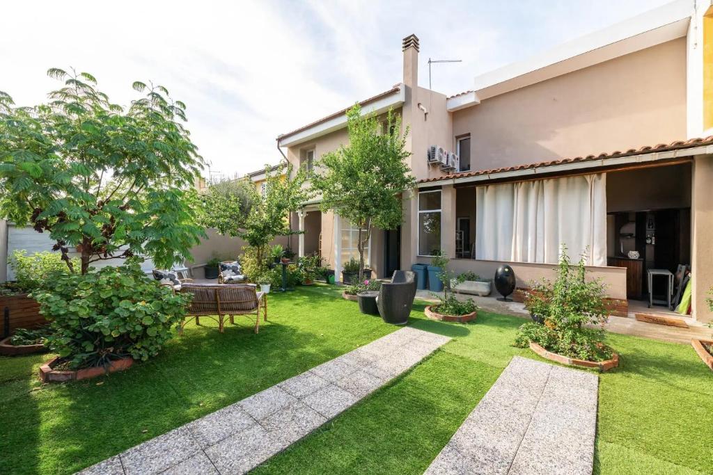 a garden with grass and trees in front of a house at Luxi noa in Quartu SantʼElena