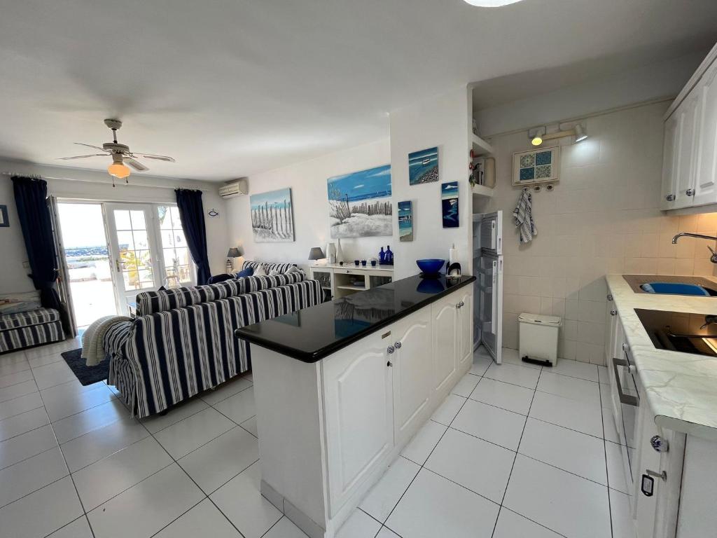 a kitchen and a living room with a couch at Puerto Chico F in Playa Blanca
