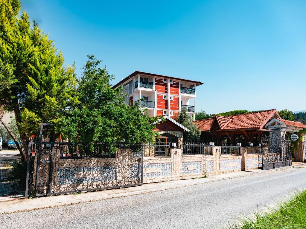 a fence in front of a house with a building at Melrose Pansiyon in Pamukkale