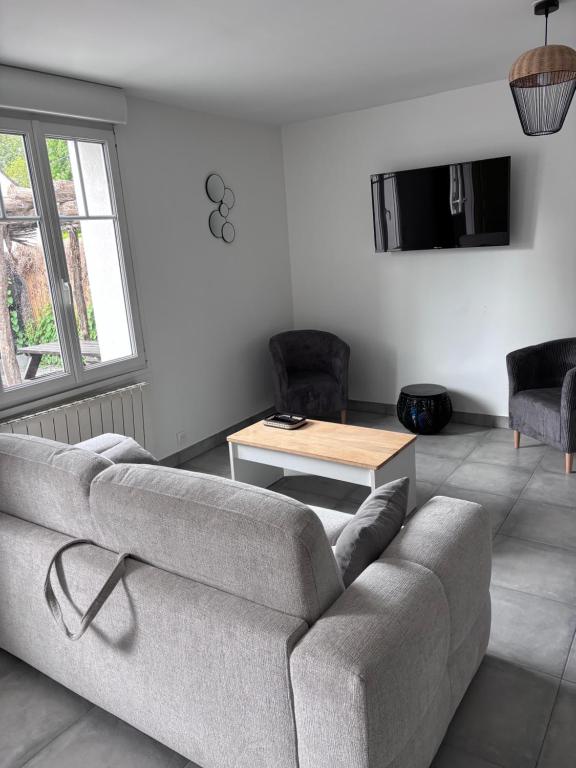 a living room with a couch and a table at Maison proche plage in Merlimont
