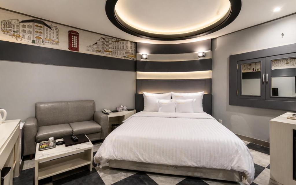 a bedroom with a bed and a chair at Hive Hotel in Tongduch'ŏn