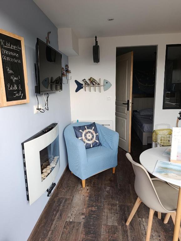 a living room with a blue chair and a table at Bienvenue chez Marceau in Le Crotoy