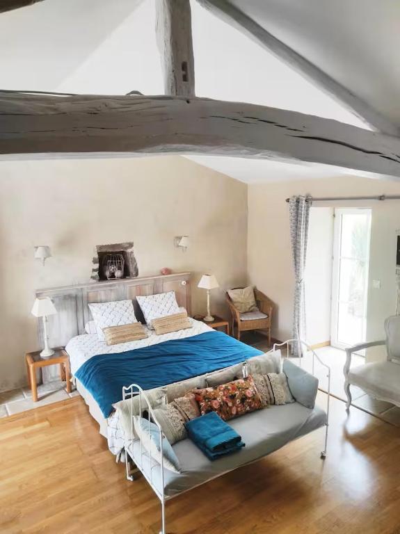 a bedroom with a bed and a couch in it at Les Jardins de la Pinellerie in Vue