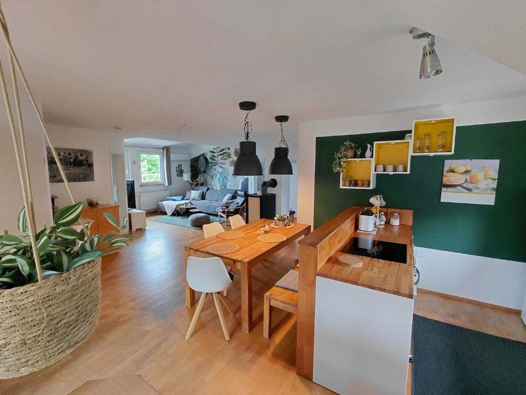 a kitchen and living room with a wooden table at Ferienwohnung am Sendberg in Frielendorf