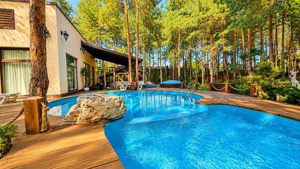 a swimming pool in the middle of a yard at Дом в лесу 1dom club in Protsev