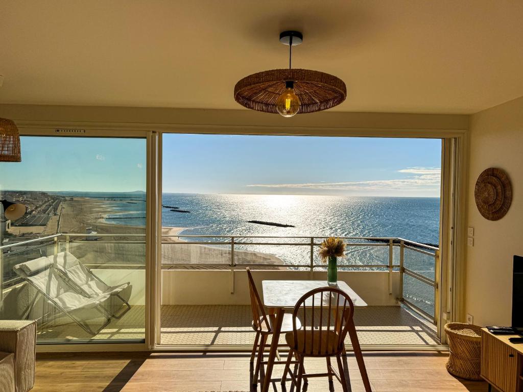 a dining room with a view of the ocean at La Tour Alba in Valras-Plage