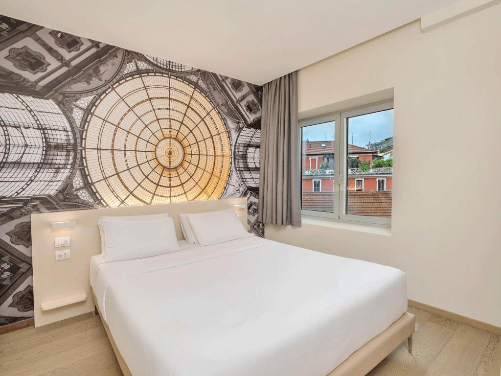 a bedroom with a white bed and a mural at B&B Hotel Milano Central Station in Milan