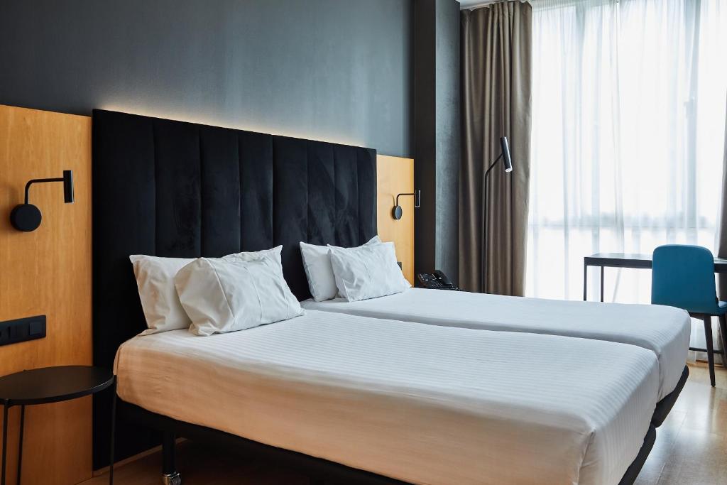 a bedroom with a large bed with a black headboard at Silken Sant Gervasi in Barcelona