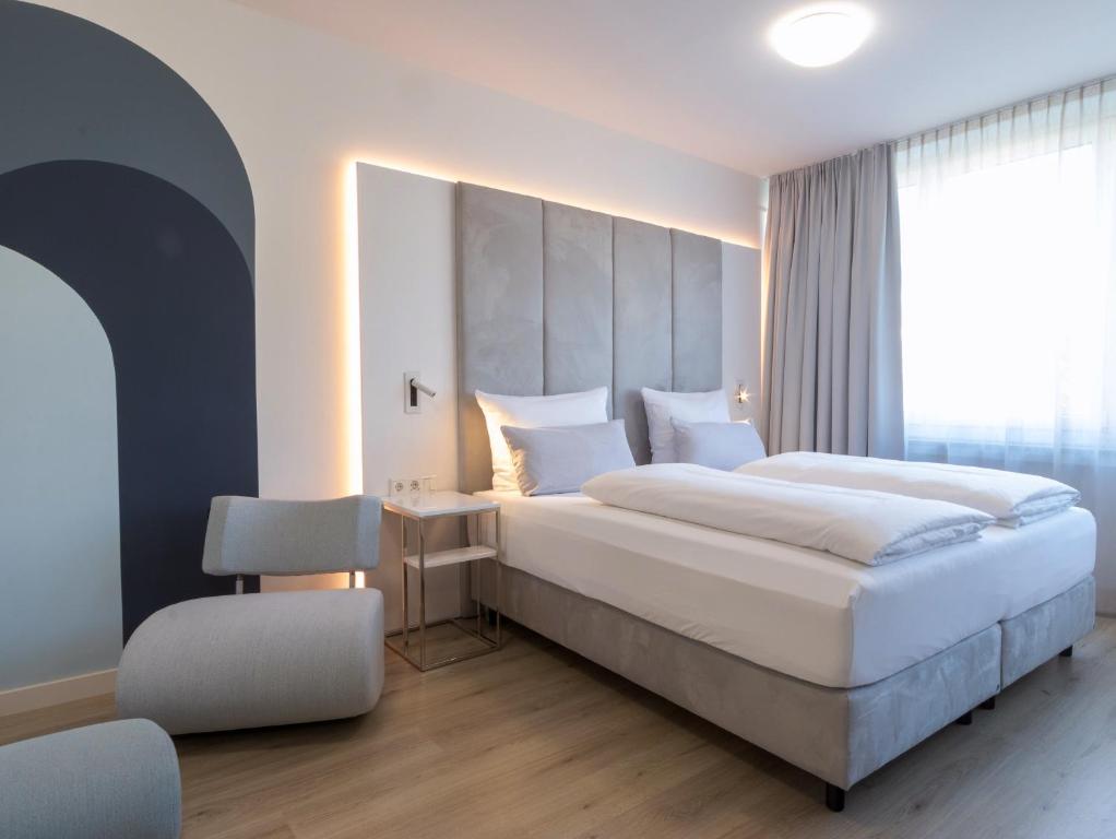 a hotel room with two beds and a desk at zzzpace Smart-Hotel Bielefeld Zentrum in Bielefeld