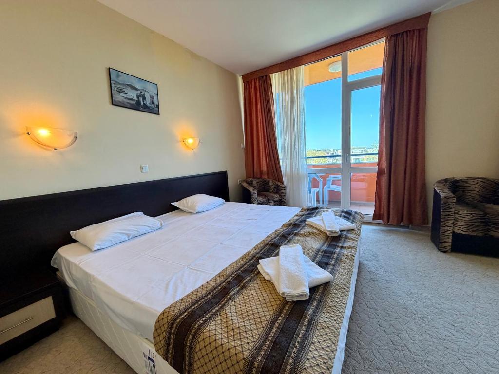 a hotel room with a bed and a large window at Hotel Amaris in Sunny Beach