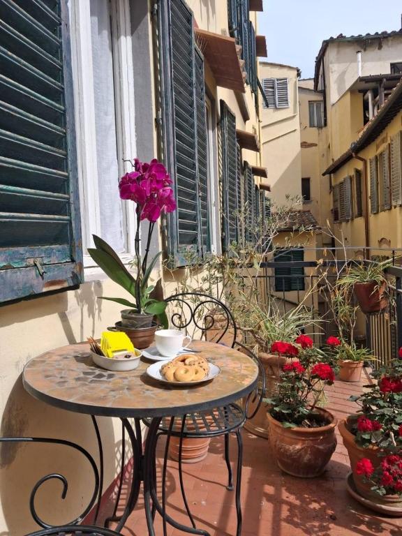 a table with a plate of food on a balcony at Fashion Florence Rooms in Florence