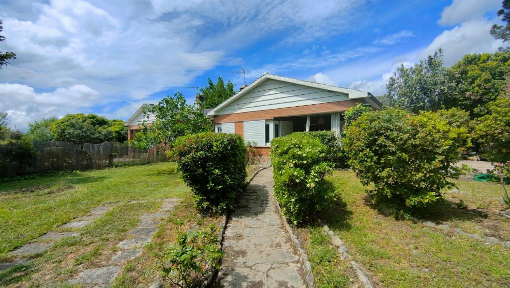a house with hedges in front of a yard at Villa Lorelia in La Adrada