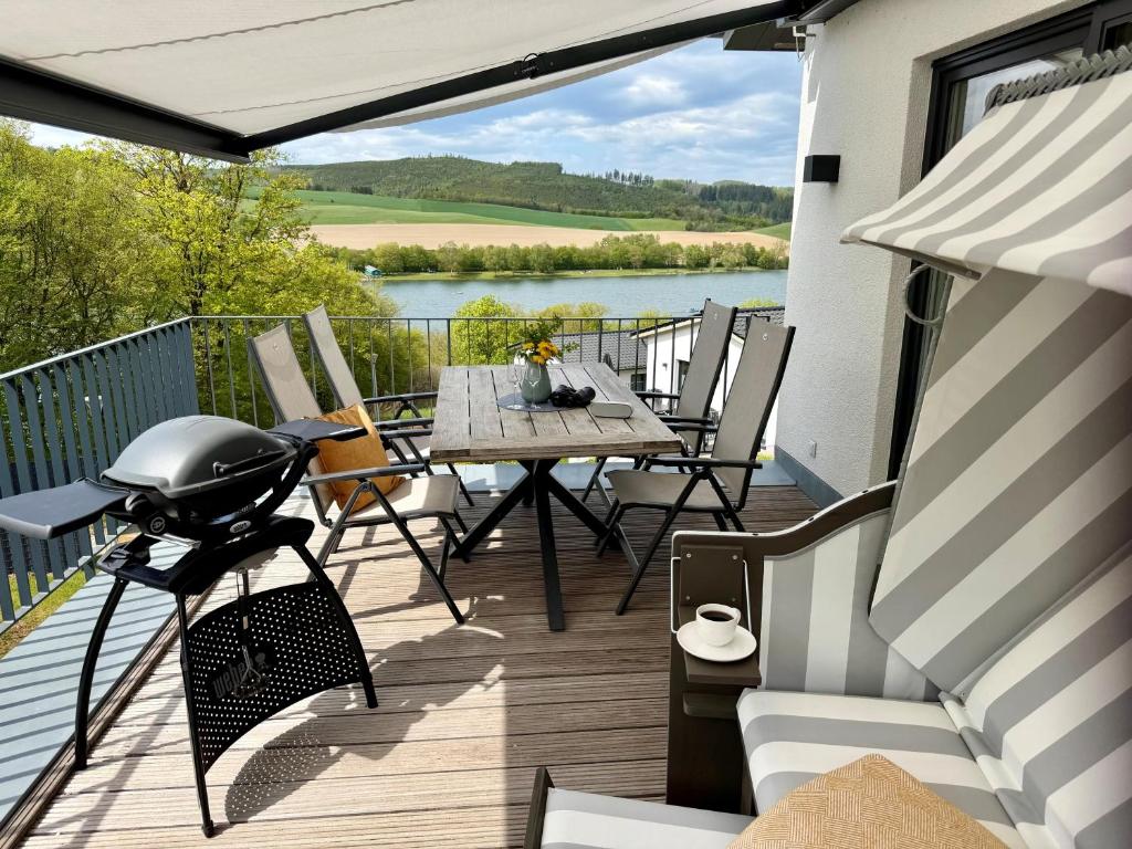 a patio with a table and chairs on a balcony at Diemeleck - Diemelblick 10 in Heringhausen