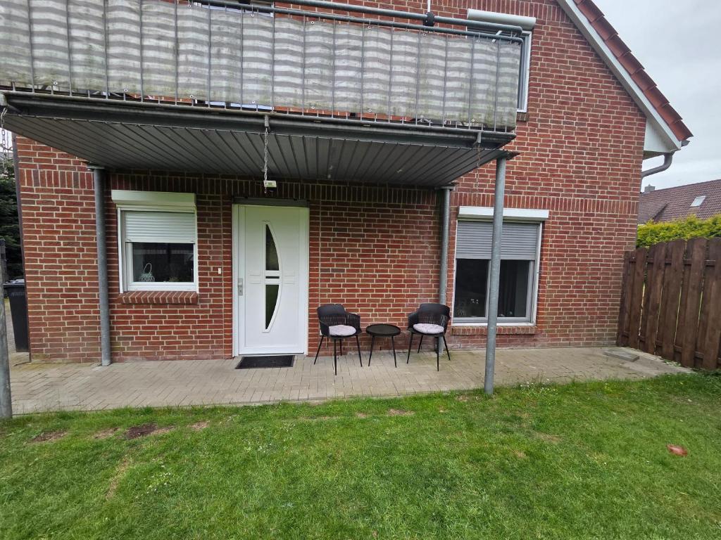 a house with a patio with chairs and a white door at Haus Küstenheide in Cuxhaven