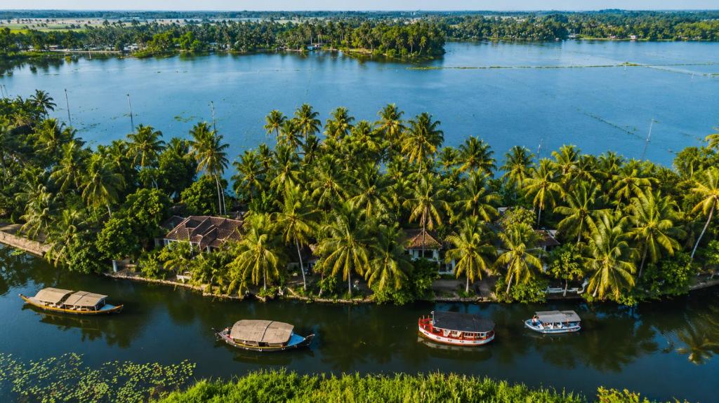 an aerial view of a resort on a river with palm trees at Amritara A Beach Symphony in Mararikulam