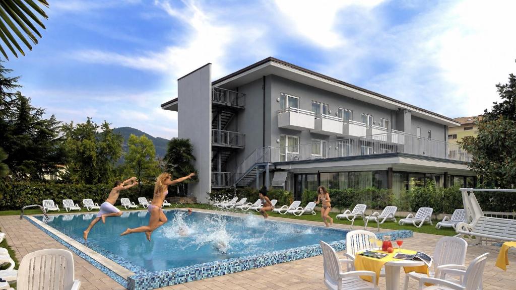 a group of girls jumping in a swimming pool at Hotel Campagnola in Riva del Garda