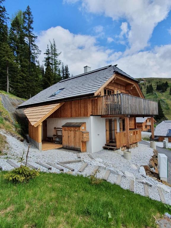 a large wooden house with a balcony on a yard at Almchalet Schweigerbuam Lachtal in Hinteralm