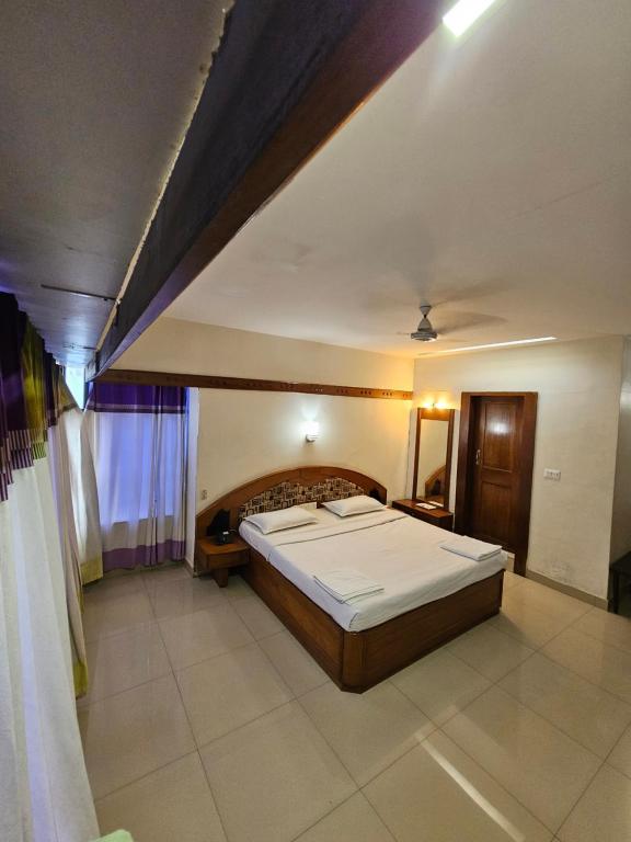 a bedroom with a large bed in a room at Hotel Gazala in Palakkad