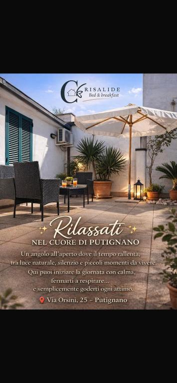 a sign for a restaurant with chairs and an umbrella at B&B Crisalide in Putignano