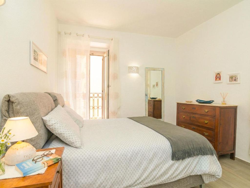 a bedroom with a bed and a dresser and a window at Apartment Nuraghi by Interhome in Arzachena