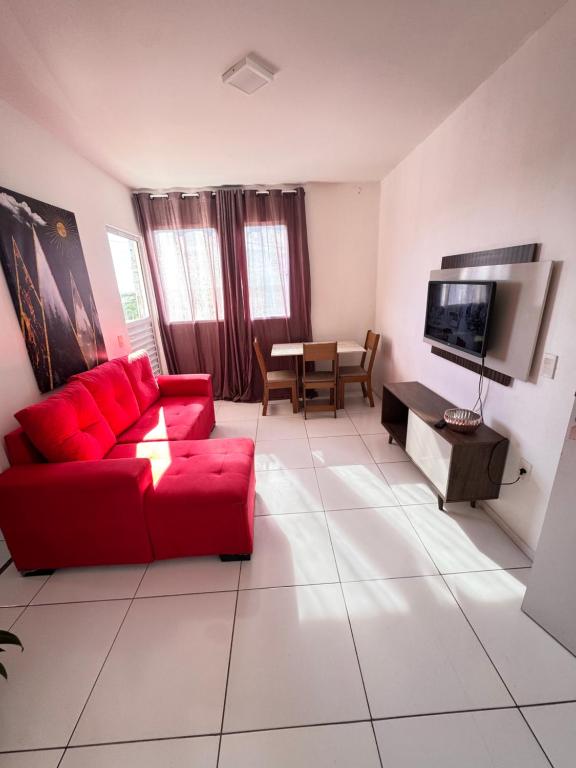 a living room with a red couch and a table at Refúgio Aconchegante Solares in Petrolina