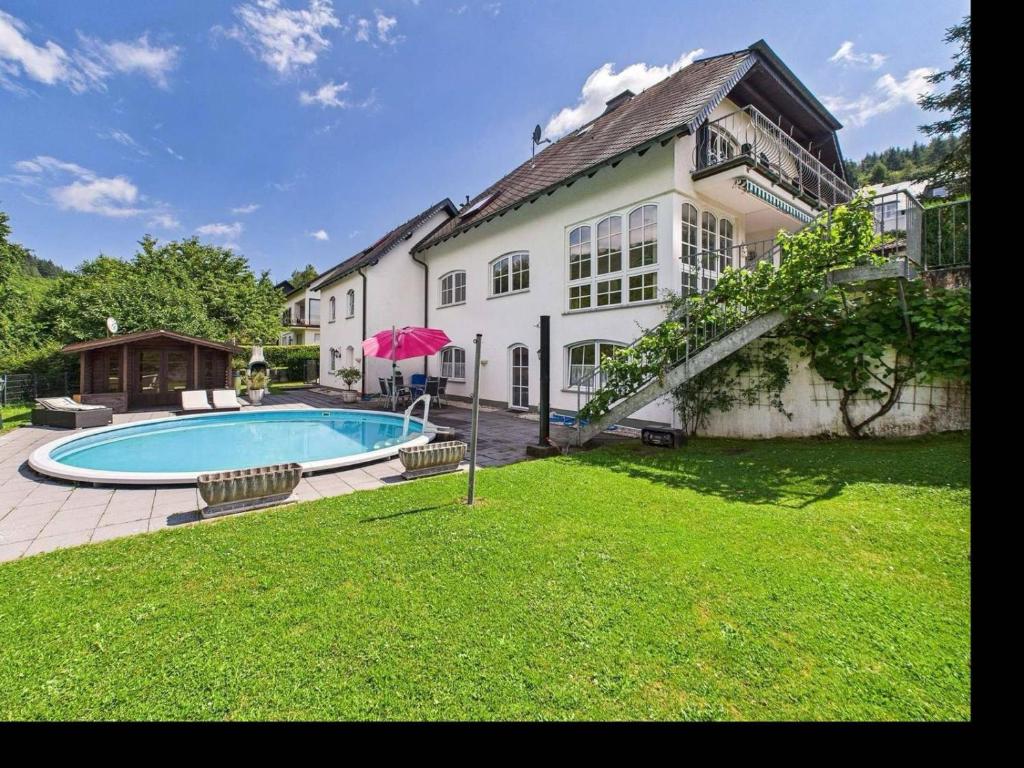 a large house with a swimming pool in the yard at Moseloase am Weinberg mit Pool und Sauna in Bullay in Alf
