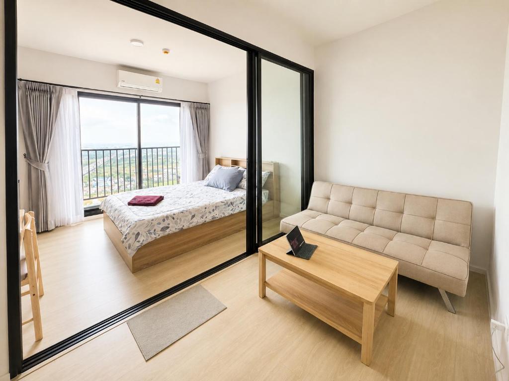 a large mirror in a bedroom with a bed and a couch at Lucky 98 Sky Stay in Bang Phli