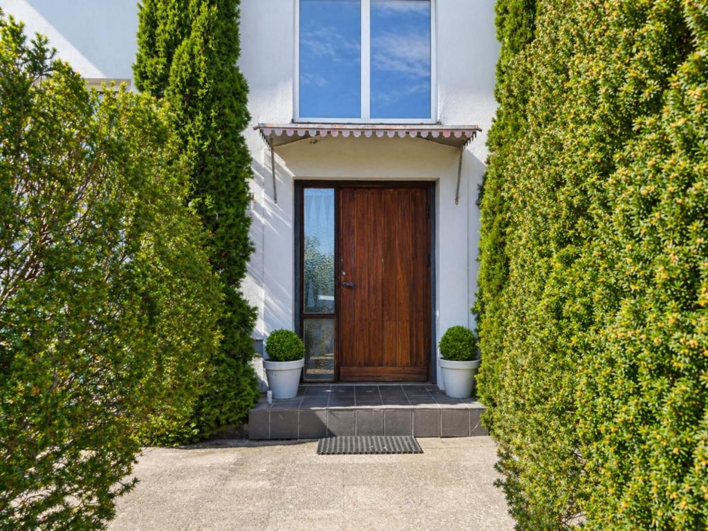 a house with a wooden door between two bushes at Apartment Brömsebro by Interhome in Halmstad