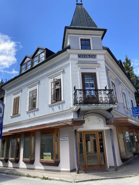 a white building with a balcony on a street at Ferienwohnung Marienhof in Bad Aussee