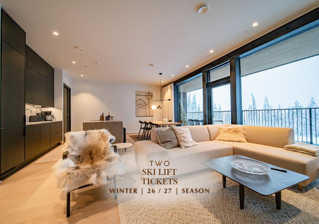a living room with a couch and a table at Fjällen Aurora Luxe Chalet Ski-in Ski-out by Aavalevi in Levi