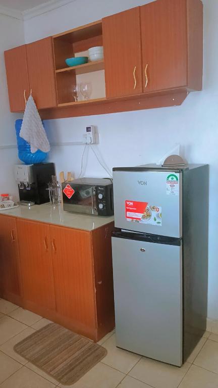 a kitchen with a refrigerator and a microwave at Min cozy homes in Eldoret