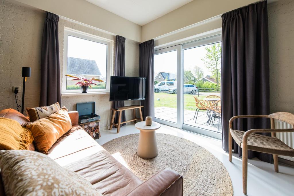 a living room with a couch and a tv at Strandweg Appartement in Buren