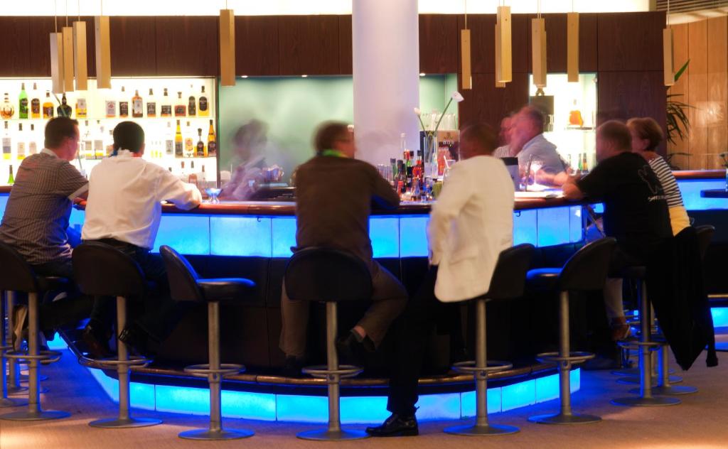 a group of people sitting at a bar at Hotel Neptun in Warnemünde