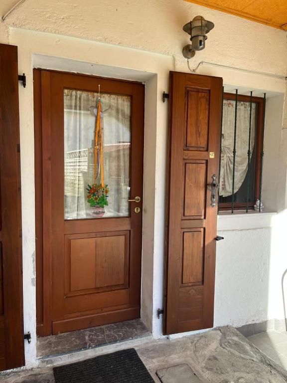 a house with a wooden door and a window at Lûc Dal Aur in Sùtrio