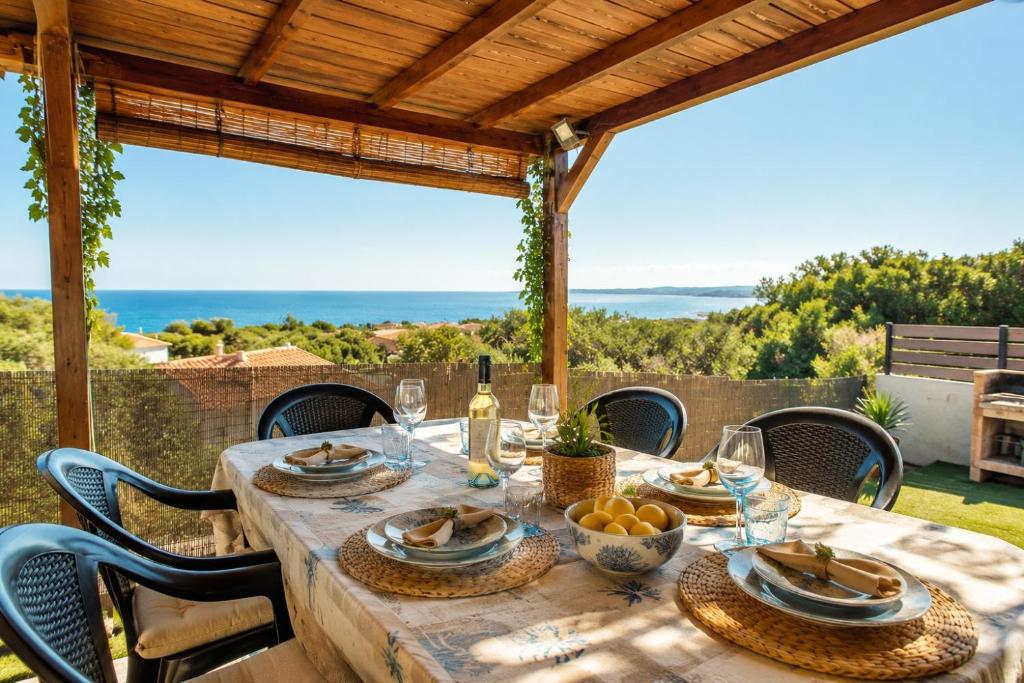 a dining table with a view of the ocean at AMBRA - Casa Vista Mare in San Teodoro