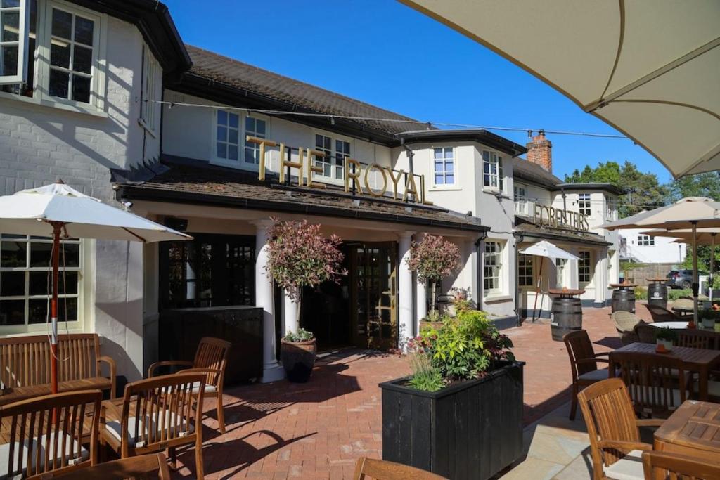 an outdoor patio with tables and chairs in front of a hotel at The Royal Foresters, Ascot, Berkshire - Acorn Pubs in Ascot