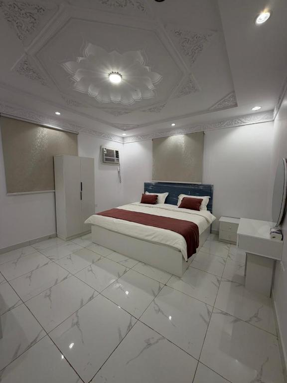 a bedroom with a large bed in a white room at غرفتين وصالة النبلاء in Medina