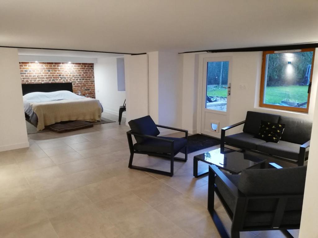 a living room with a bed and a couch and chairs at Souplex Michelet in Arras