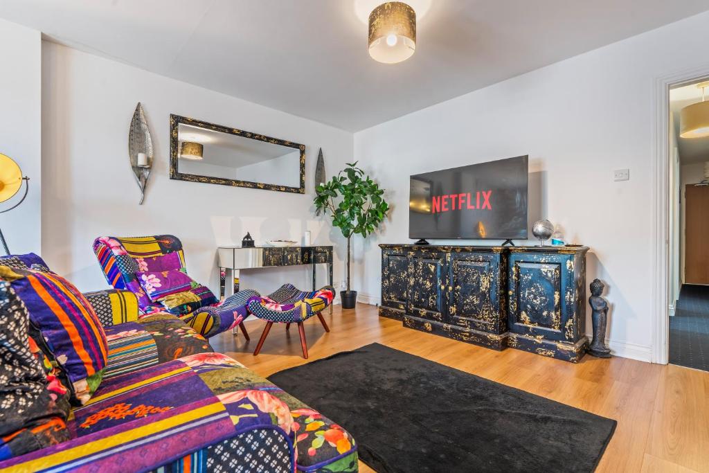 a living room with a couch and a tv at 3BR Pontypool Haven - Sleeps 6 with Parking in Pontnewynydd