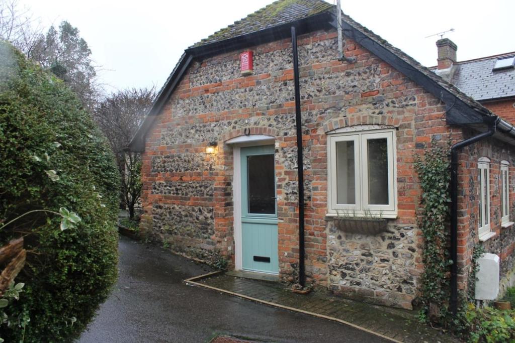 a brick house with a blue door and a window at Charming Converted Stable in Ramsbury for Two in Ramsbury